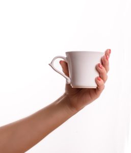 hand holding a white cup