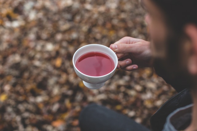 A man holding a cup of kratom tea