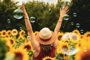 Woman happy in a sunflower field after learning other uses of kratom