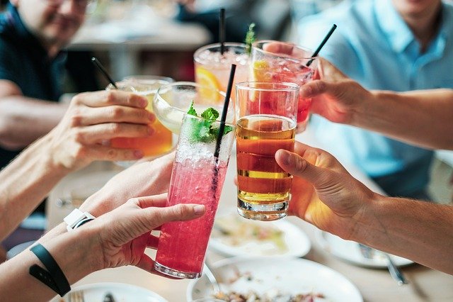 People toasting with colorful cocktails.