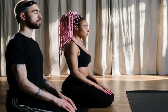 A couple meditating to relieve anxiety