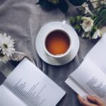 Tea cup surrounded by flowers and books