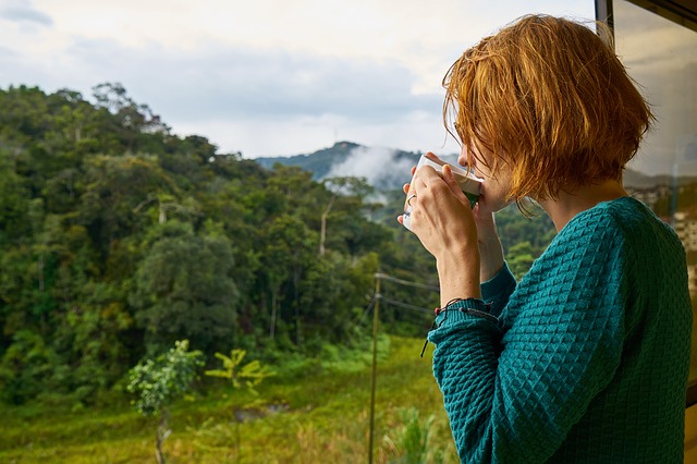A woman drinking kratom in the morning in the middle of the mountains